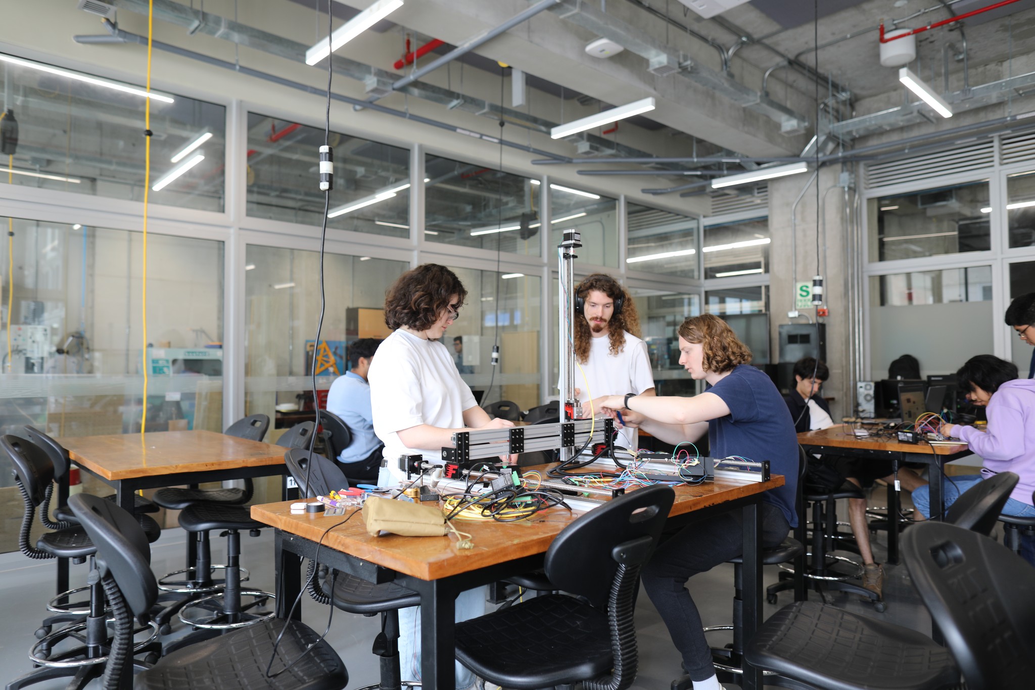 Tres estudiantes extranjeros realizan actividades en un laboratorio de UTEC, como parte de su experiencia de intercambio académico en un entorno de innovación y aprendizaje práctico.
