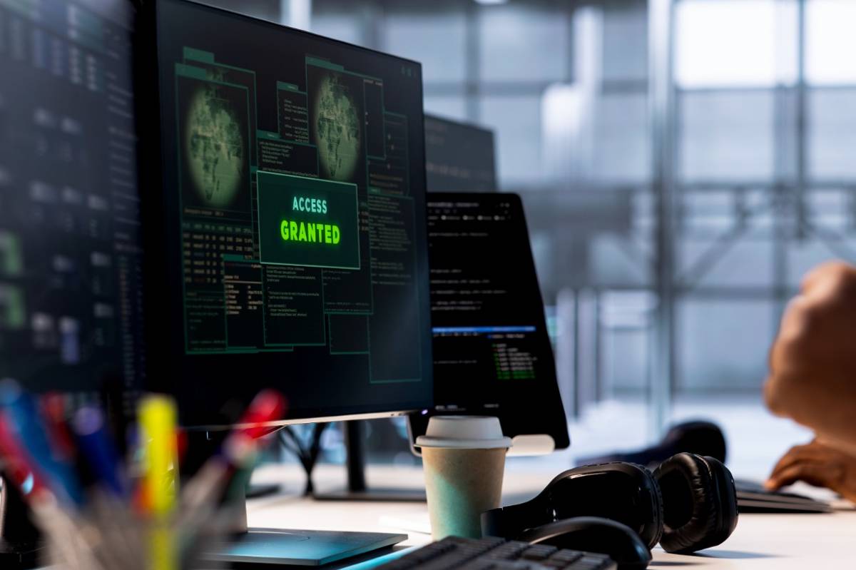 Monitor de computadora en un centro de datos mostrando un mensaje de "Access Granted" verde, destacando protocolos de ciberseguridad y protección de servidores