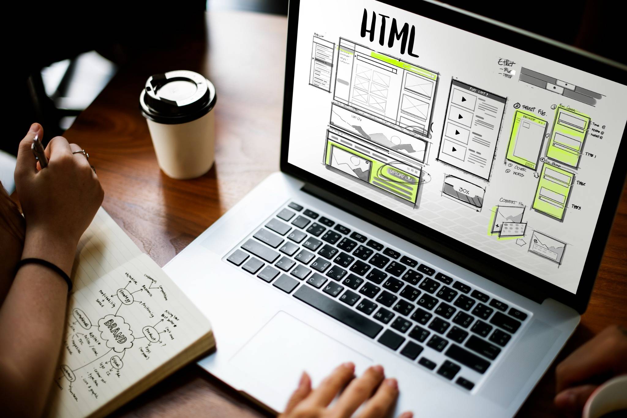 Laptop con bocetos técnicos de HTML y esquemas que ilustran la organización de componentes en la arquitectura de software para aplicaciones web