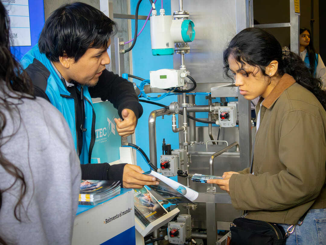 Un orientador explica a una estudiante el funcionamiento de sistemas automatizados vinculados a las carreras con inteligencia artificial